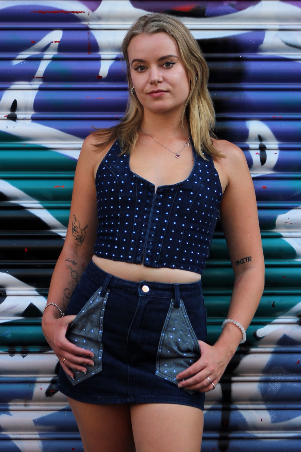 Urban portrait of Niamh against blue graffiti