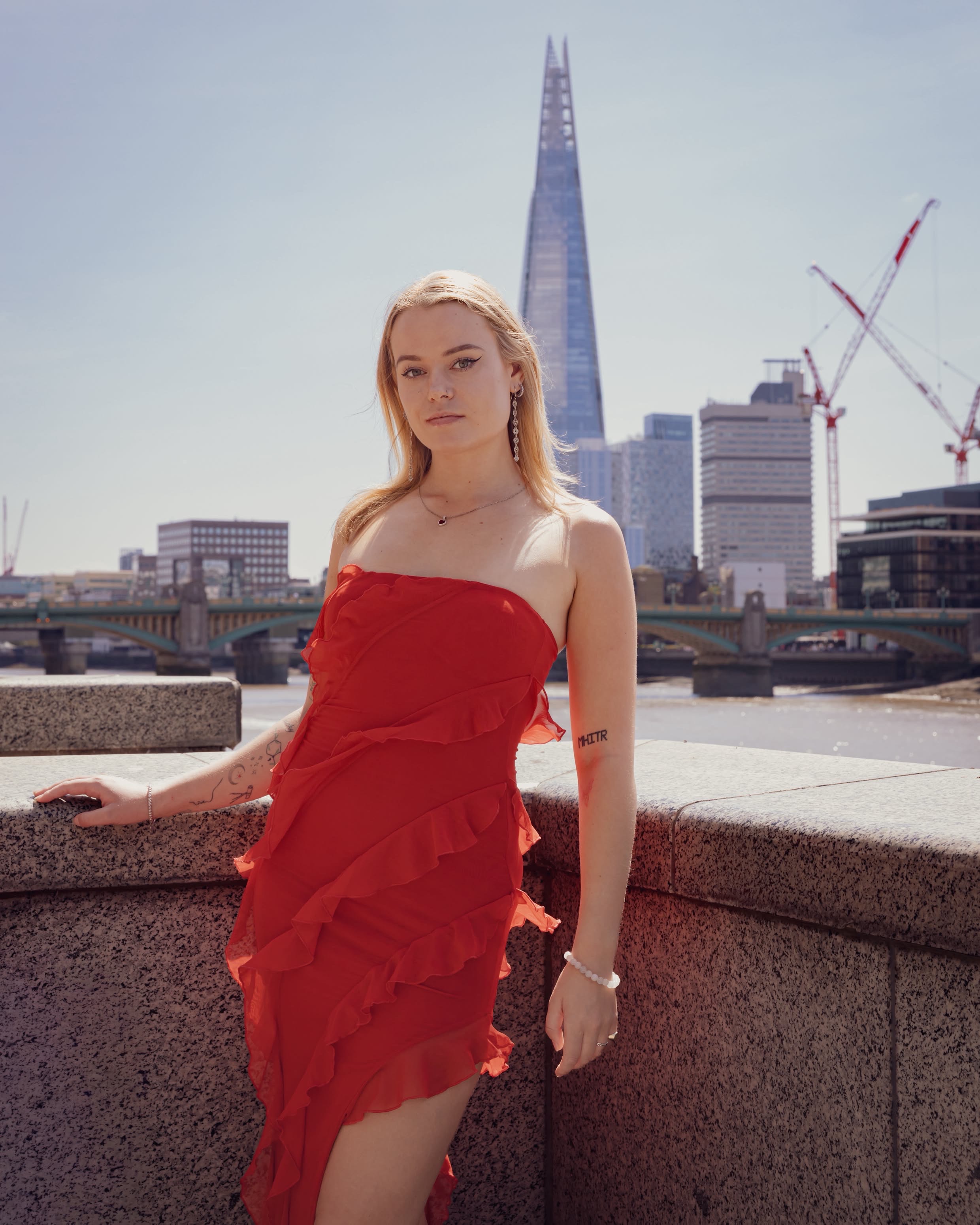 Niamh modelling a red dress with the Shard behind her