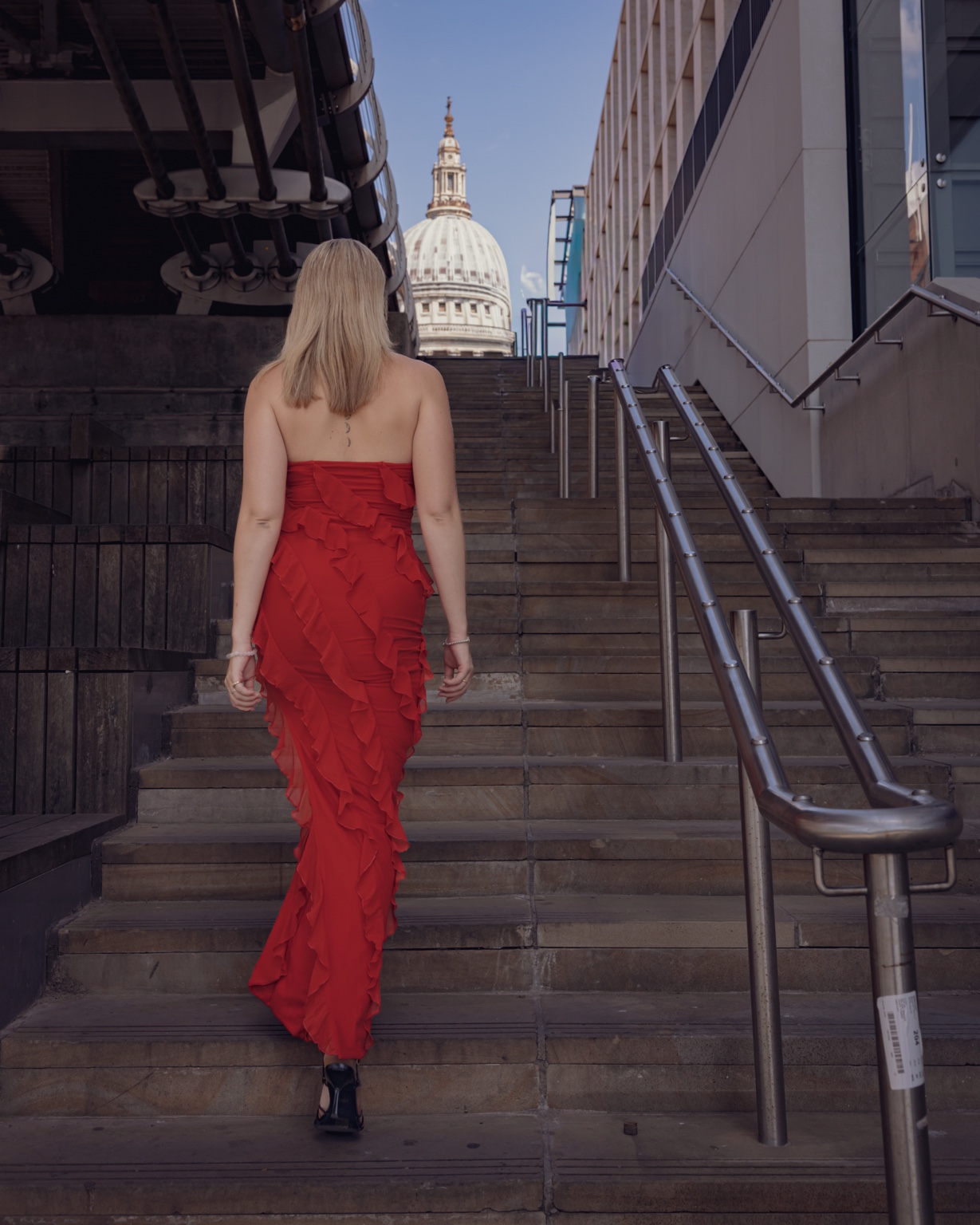 Niamh walking toward St Paul's in a red dress
